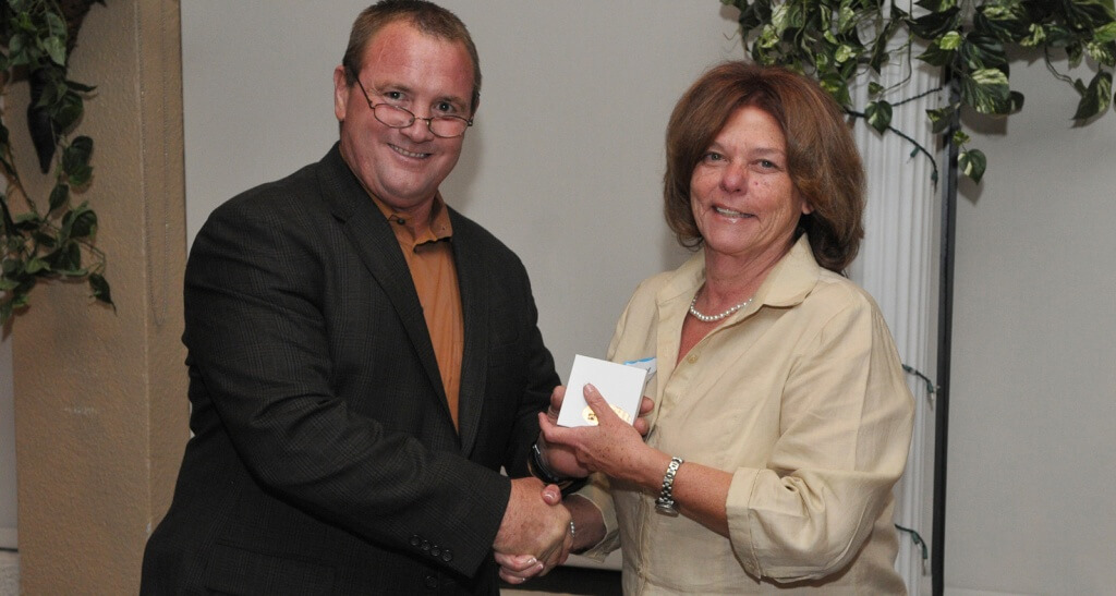 Former Dade County Farm Bureau Board member John Alger, left, presents an award to Ivonne Alexander.